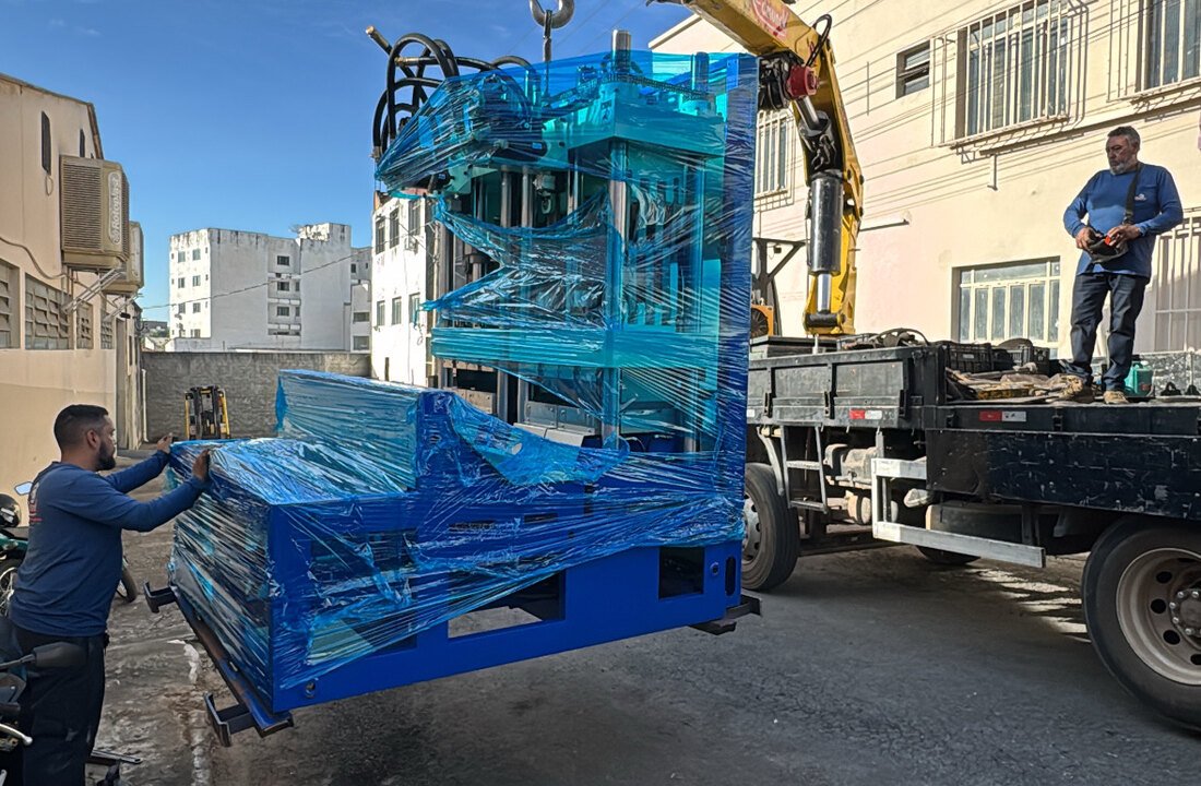 Máquina industrial sendo movimentada por guindaste